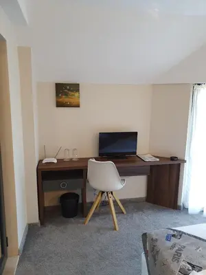 a room with a desk with a chair and a computer at Family Hotel Novel City in Burgas City