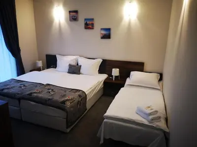 a hotel room with two beds and two towels at Family Hotel Novel City in Burgas City