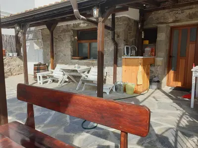 a wooden bench sitting on a patio with a table at Guest House Antique in Sozopol