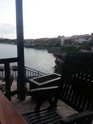 a bench sitting on a balcony overlooking a river at Guest House Antique in Sozopol