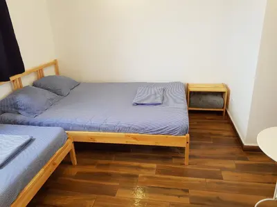 a bedroom with two beds and a wooden floor at Guest House Antique in Sozopol