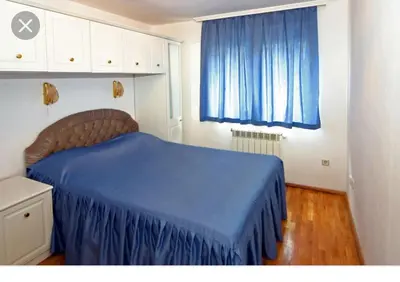 a bedroom with a blue bed and a blue curtain at Apartment Pier in Varna City
