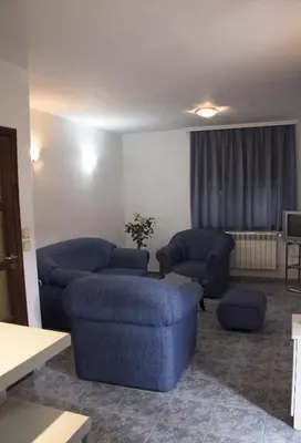 a living room with two blue couches and a table at Apartment Pier in Varna City