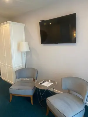 a room with two chairs and a table and a flat screen tv at Hotel Residence Promenade in Burgas City