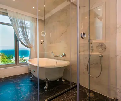 a bathroom with a tub and a glass shower at Hotel Residence Promenade in Burgas City