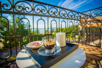 a tray with a cup of tea on a table on a balcony at Hotel Residence Promenade in Burgas City
