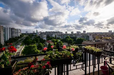 a balcony with potted plants and a view of a city at Sky Garden Apartment Burgas in Burgas City