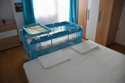 a blue suitcase sitting on a bed in a room at Aglaya 2 in Pomorie