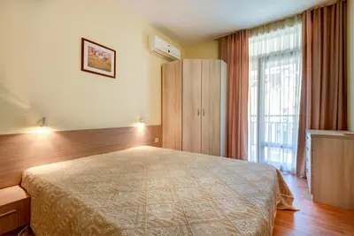 a bedroom with a bed and a cabinet and a window at ДриймБг Апартаменти - Райска Градина, Свети Влас in Sveti Vlas