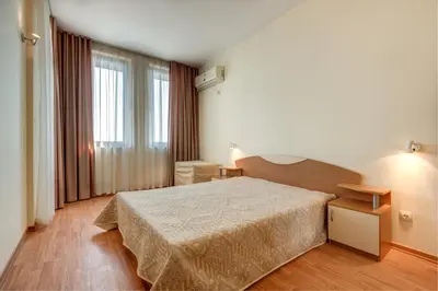 a bedroom with a bed and a large window at ДриймБг Апартаменти - Райска Градина, Свети Влас in Sveti Vlas