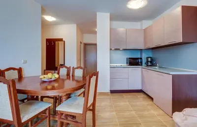 a kitchen and dining room with a table and chairs at ДриймБг Апартаменти - Парадайз Дриймс, Свети Влас in Sveti Vlas
