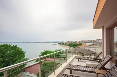a balcony with benches and a view of the water at Villa Tuna in Sveti Vlas