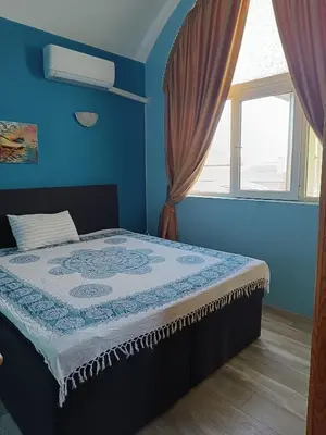 a bed in a blue room with a window at Arte Casa in Burgas City
