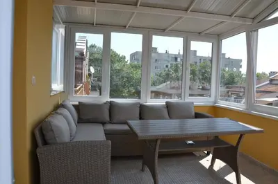 a living room with a couch and a table and windows at Arte Casa in Burgas City