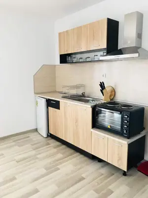 a kitchen with wooden cabinets and a black microwave at Dream View in Byala