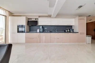 a large kitchen with white cabinets and a sink at Apartcomplex Golden Bay in Ravda