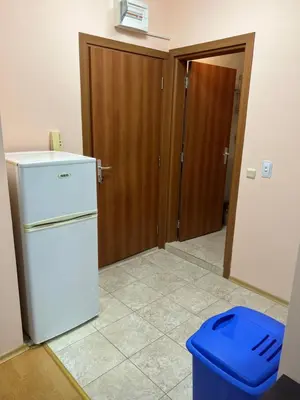 a kitchen with a white refrigerator and a blue trash can at Частен апартамент Лагуна - Private Two-Bedroom Apartment Laguna in Primorsko