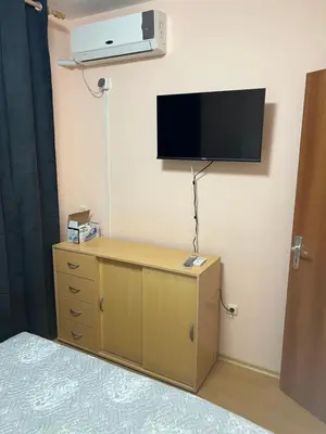 a room with a dresser with a tv on the wall at Частен апартамент Лагуна - Private Two-Bedroom Apartment Laguna in Primorsko