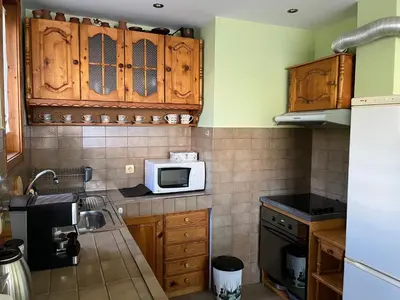 a kitchen with wooden cabinets and a microwave at Одеса 37 in Sozopol