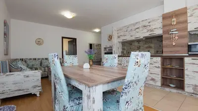 a dining room with a wooden table and chairs at Lora boutique in Pomorie