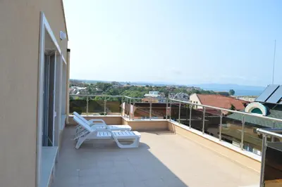 a balcony with two white lounge chairs on a roof at SummerHouse Lozenets in Lozenets