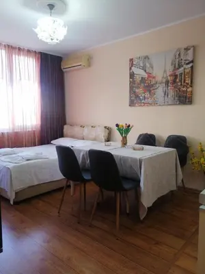 a room with a table with chairs and a bed at Apartament ,,EDELVAIS- LUX'' in Nesebar