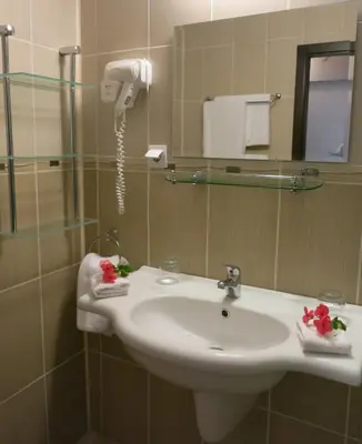 a bathroom with a sink and a shower at Family Hotel Albizia Beach in Varna City