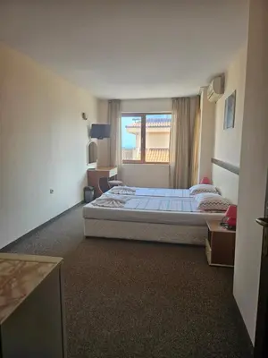 a hotel room with a bed and a window at Hotel Orchidea in Sozopol