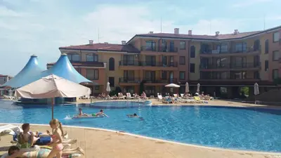 a group of people in a swimming pool next to a building at Apartcomplex Panorama Dreams in Sveti Vlas