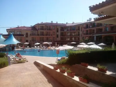 a swimming pool with umbrellas and people in a hotel at Apartcomplex Panorama Dreams in Sveti Vlas