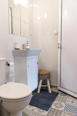 a bathroom with a toilet and a sink and a stool at Balabanov White in Varna City