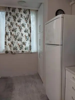 a kitchen with a white refrigerator and a window at Sweet Home in Burgas City