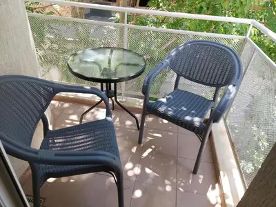 two chairs and a glass table on a balcony at Apartment Larissa in Pomorie
