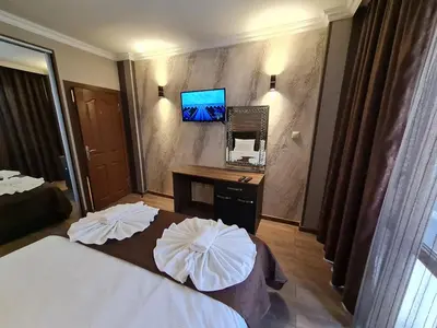 a hotel room with a bed and a desk and a television at MitProt Panorama Bay 2 luks Apartment ap100 in Sveti Vlas
