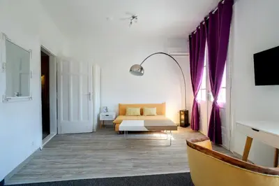a bedroom with a bed and purple curtains at Hostel Musala in Varna City
