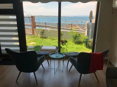 a room with chairs and a table and a view of the ocean at Villa Victoria - a luxury appartment with icredible Seaview in Sozopol