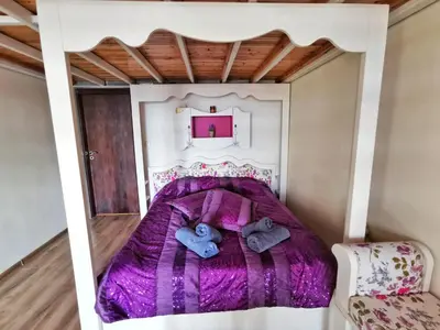 a bedroom with a bed with purple comforter at Villa Victoria - a luxury appartment with icredible Seaview in Sozopol