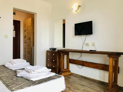 a room with two beds and a television on a wall at Villa Adrian in Shkorpilovtsi