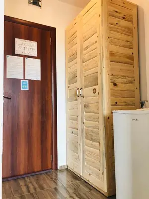 a room with a wooden door and a refrigerator at Villa Adrian in Shkorpilovtsi