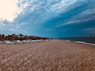 a beach with chairs and umbrellas and the ocean at Villa Adrian in Shkorpilovtsi