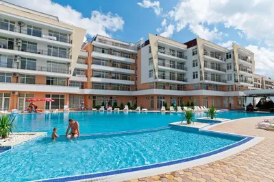 a man and a child in the swimming pool at a hotel at Grand Kameliq in Sunny Beach