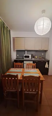 a kitchen with a wooden table with two chairs and a dining room at Grand Kameliq in Sunny Beach