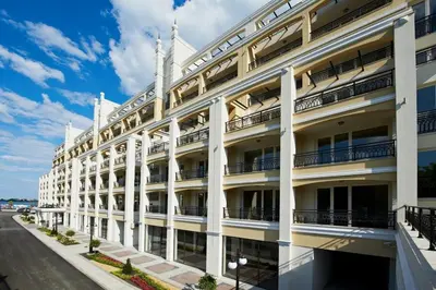 a large white building with balconies and a street at Penelopa Palace Apart Hotel & SPA in Pomorie