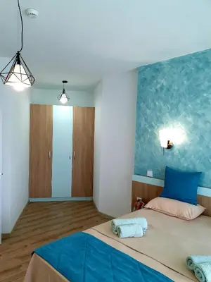 a bedroom with a bed with a blue wall at Old Sailor Apartment in Obzor