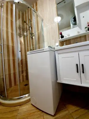 a bathroom with a shower and a white cabinet at Old Sailor Apartment in Obzor