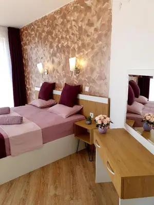 a bedroom with two beds and a desk and a mirror at Old Sailor Apartment in Obzor