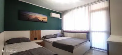 two beds in a room with a green wall at Семейна къща “Вълчеви” in Kiten