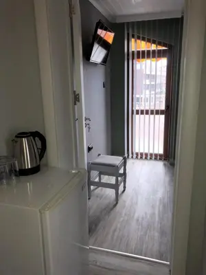 a kitchen with a table and a chair and a refrigerator at Семейна къща “Вълчеви” in Kiten