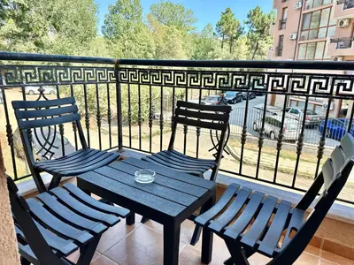 a wooden table and two chairs on a balcony at Efir 2 - Menada Apartments in Sunny Beach
