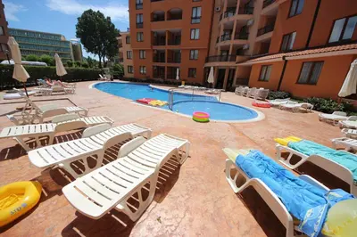 a swimming pool with chaise lounges and a bunch of chairs at Efir 2 - Menada Apartments in Sunny Beach